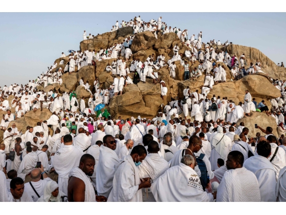 Muslim pilgrims pray at dawn on Saudi Arabia's Mount Arafat, also known as Jabal al-Rahma or Mount of Mercy, during the climax of the Hajj pilgrimage on May 26, 2026. (Photo by Zain JAAFAR / AFP)