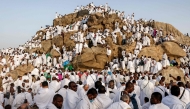 Muslim pilgrims pray at dawn on Saudi Arabia's Mount Arafat, also known as Jabal al-Rahma or Mount of Mercy, during the climax of the Hajj pilgrimage on May 26, 2026. (Photo by Zain JAAFAR / AFP)
