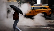 A woman holding an umbrella crosses the street in the rain in New York City, on May 24, 2026. Photo by CHARLY TRIBALLEAU / AFP