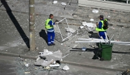 Municipal workers clear debris from the street after a Russian drone struck an apartment building in Galati, western Romania. (Photo by Daniel Mihailescu / AFP)
 