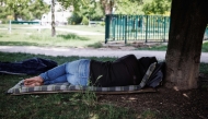 A person lies on a mattress under a tree in a park, in Paris on May 29, 2026 as a heatwave hits France.  (Photo by Simon Wohlfahrt / AFP)