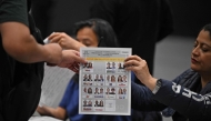 A voter receives his ballot a polling station during the presidential election in Bogota on May 31, 2026. (Photo by Luis ACOSTA / AFP)