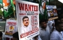 Indian Youth Congress party workers hold placards of India's Education Minister Dharmendra Pradhan during a protest against National Testing Agency (NTA) in Mumbai on June 2, 2026. (Photo by Indranil Mukherjee / AFP)
