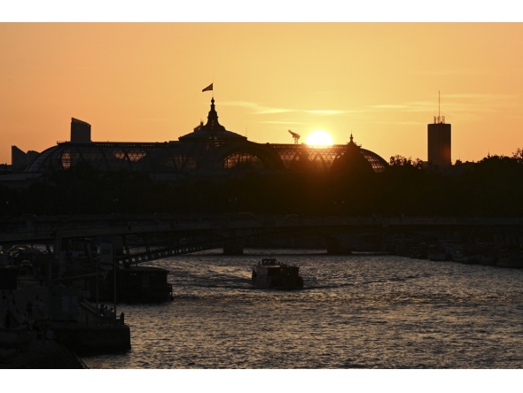 A tourist boat sails along the Seine river at sunset with the Grand Palais in the background, in Paris on 26 May 2026. (Photo by Christophe DELATTRE / AFP)
