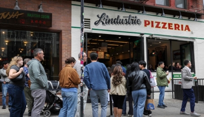 People wait in line outside L'industrie Pizzeria in New York City on May 15, 2026. (Photo by Angela Weiss / AFP)