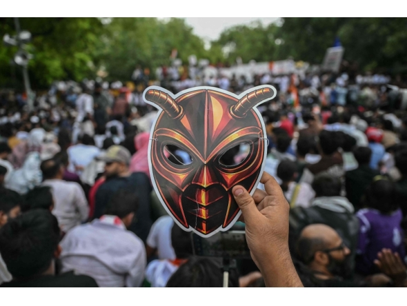 A Cockroach Janta Party (CJP) supporter holds a cockroach mask during a protest over alleged irregularities in the country's major examinations, in New Delhi on June 6, 2026. (Photo by Arun Sankar / AFP)