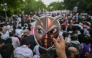 A Cockroach Janta Party (CJP) supporter holds a cockroach mask during a protest over alleged irregularities in the country's major examinations, in New Delhi on June 6, 2026. (Photo by Arun Sankar / AFP)