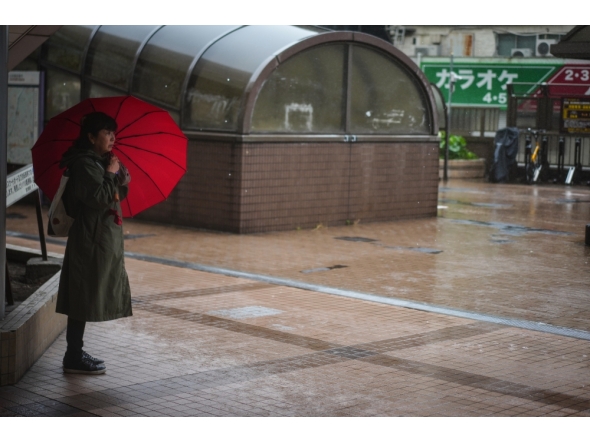 (FILE PHOTO) A woman holding an umbrella stands on a street in rain brought by Typhoon Jangmi in Tokyo, Japan, June 3, 2026. (Xinhua/Jia Haocheng)
