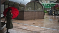(FILE PHOTO) A woman holding an umbrella stands on a street in rain brought by Typhoon Jangmi in Tokyo, Japan, June 3, 2026. (Xinhua/Jia Haocheng)
