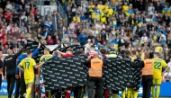 Denmark's and Ukraine's players huddle to accompany Christian Eriksen to a waiting ambulance during the football international friendly match between Denmark and Ukraine at Odense Stadium in Denmark, on June 7, 2026.  (Photo by Bo Amstrup / Ritzau Scanpix / AFP) / Denmark OUT