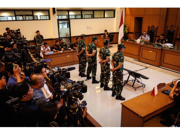 Four Indonesian military personnel accused of throwing acid at a human rights activist attend a verdict hearing at a military court in Jakarta on June 10, 2026. (Photo by Yasuyoshi Chiba / AFP)