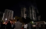 Bystanders look on after a major fire swept through several apartment blocks at the Wang Fuk Court residential estate in Hong Kong's Tai Po district on November 27, 2025. Photo by Philip FONG / AFP