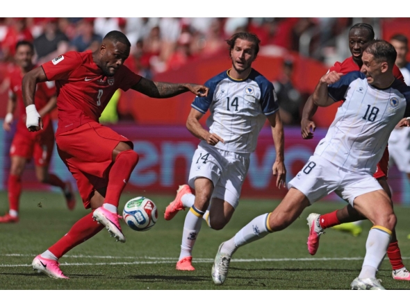 Canada's forward #09 Cyle Larin (L) scores the equalizer during the 2026 World Cup Group B football match between Canada and Bosnia and Herzegovina at the Toronto Stadium in Toronto on June 12, 2026. (Photo by Cole Burston / AFP)
