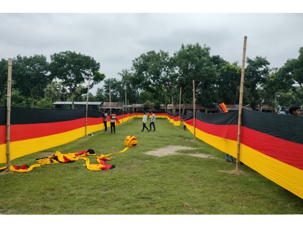 People look at a 7.5 kilometres (4.7 miles) long national flag of Germany commisioned by their football team fan Bangladeshi farmer Amjad Hossain, upon its display across a field in Magura district on June 10, 2026, on the eve of the 2026 FIFA World Cup tournament. Photo by AFP
