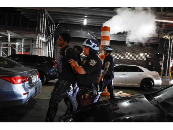 NYPD officers arrest a man after the New York knicks defeated the San Antonio Spurs in Game 5 of the NBA Finals to win the series, in New York, on June 14, 2026.
(Photo by kena betancur / AFP)