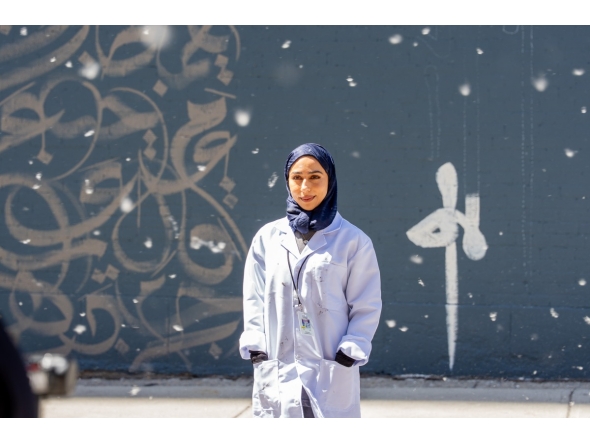 Fatima Alsharshani in front of her mural in Montreal.