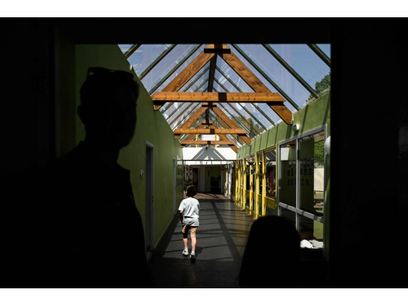 (Files) A child walks along the glass-roofed corridor of the Isle Verte primary school on May 28, 2026. (Photo by Philippe Lopez / AFP)