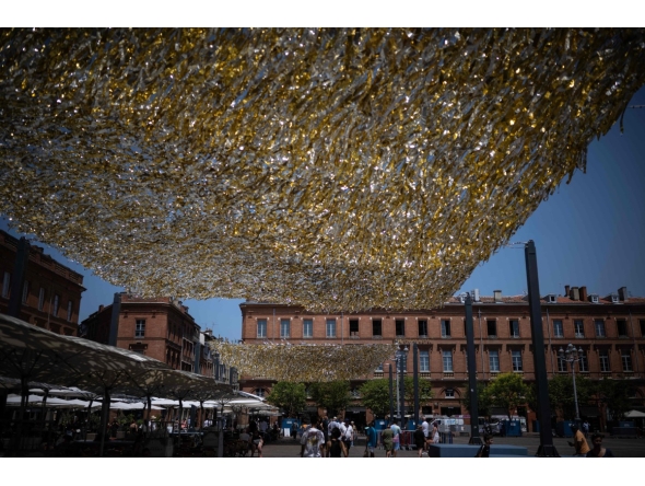 People walk through the Capitole square covered by an installation to provide shade, in Toulouse on June 19, 2026. Photo by Lionel BONAVENTURE / AFP