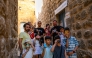 A group of children pose with their educators as they take pictures in the streets with film cameras during a workshop on June 14, 2026. (Photo by Yasin Akgul / AFP)