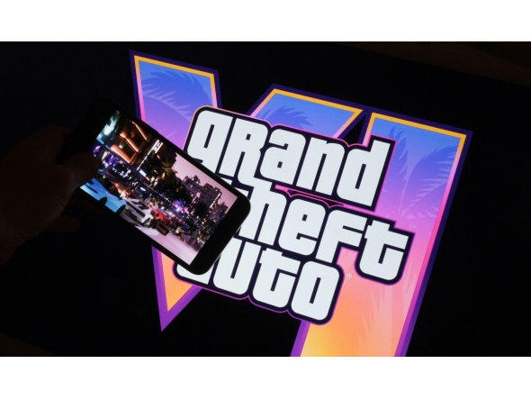 This illustration photo created in Los Angeles, December 4, 2023, shows Rockstar Games’ Grand Theft Auto VI trailer played on a screen in front of the game title. Photo by Chris DELMAS / AFP