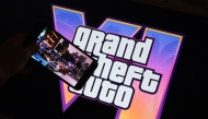 This illustration photo created in Los Angeles, December 4, 2023, shows Rockstar Games’ Grand Theft Auto VI trailer played on a screen in front of the game title. Photo by Chris DELMAS / AFP