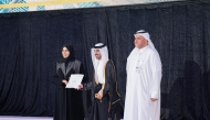 Minister of Education and Higher Education H E Lolwah bint Rashid bin Mohammed Al Khater honouring a graduate of Qatar School for Science and Technology for Boys during a ceremony.