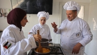 Palestinian youth learn the basics of cooking at the Smile Kitchen Academy, in the Rimal neighborhood of Gaza City on June 24, 2026. (Photo by Omar Al-Qattaa / AFP)