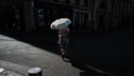 A woman walks under an umbrella to protect herself from the sun during a heatwave in Lyon, southern France, on June 24, 2026. Photo by OLIVIER CHASSIGNOLE / AFP