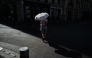A woman walks under an umbrella to protect herself from the sun during a heatwave in Lyon, southern France, on June 24, 2026. Photo by OLIVIER CHASSIGNOLE / AFP