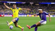 Yuto Nagatomo #5 of Japan crosses the ball while Benjamin Nygren #10 of Sweden attempts to block. Alex Slitz/Getty Images/AFP