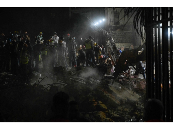 Rescue workers and volunteers search through the rubble of a collapsed building in Caracas on June 25, 2026, following a series of earthquakes. Photo by Maryorin Mendez / AFP