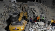 Rescue teams operate heavy machinery at the site of a collapsed building in Caracas on June 25, 2026, following earthquakes. (Photo by Juan BARRETO / AFP)