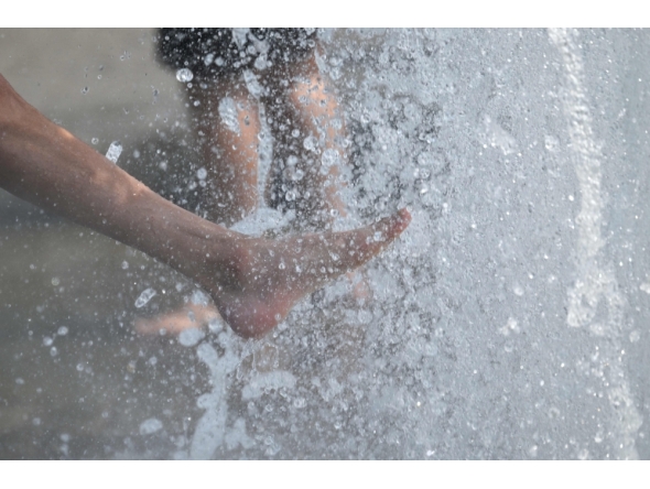 People cool off with the water of a fountain in Berlin on June 28, 2026. (Photo by Ralf Hirschberger / AFP)