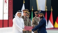 Deputy Prime Minister and Minister of State for Defence Affairs H E Sheikh Saoud bin Abdulrahman bin Hassan Al-Thani honouring a graduate during the ceremony. 