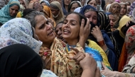 Relatives mourn the deceased children before their burial in Lahore on July 1, 2026, after the roof of a tutoring centre collapsed the previous day. Photo by Arif Ali / AFP
