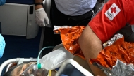 An international rescue team assists a survivor of Venezuela's twin earthquakes in Catia La Mar, La Guaira State, Venezuela on July 2, 2026, eight days after the quake. Hernan Gil, a 43-year-old security guard, had been buried in the booth of the seven-story building where he worked in Catia La Mar, a coastal area in the state of La Guaira devastated by the disaster. (Photo by Federico PARRA / AFP)
 