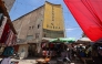Street vendors gather outside the faded facade of the Granada Cinema, an early 1940s landmark, in the Bab al-Sharqi district of central Baghdad on May 26, 2026. (Photo by Ahmad Al-Rubaye/ AFP)