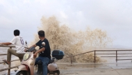 People look on as large waves crash against the coast amid weather patterns from approaching Typhoon Bavi in Wenling city, Taizhou, China's eastern Zhejiang province on July 10, 2026. (Photo by CN-STR / AFP)
 