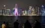 People sit facing the high-rise buildings at the Doha corniche promenade on July 21, 2026. (Photo by Mahmud Hams / AFP)
