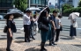 People carry umbrellas to shelter from the sun in Tokyo on July 23, 2026. (Photo by Andrew Caballero-Reynolds/ AFP)
 