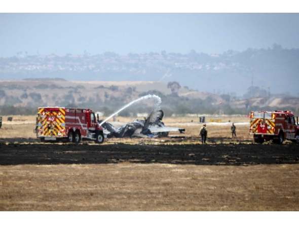 Fire crews spray down the wreckage of a US Marines’ F-35B fighter jet after it crashed into a field near Miramar Air Base in San Diego, California, on July 31, 2026.(Photo by SANDY HUFFAKER / AFP)