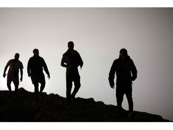 Migrants walk towards the Fnideq region in northern Morocco after leaving Spain's North African enclave of Ceuta near the town of Fnideq, on the Morocco-Spain border, following an attempted to cross at the Bab Sebta border crossing, on the Morocco- (Photo by Abdel Majid BZIOUAT / AFP)