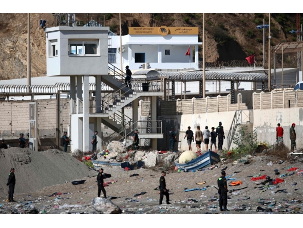 Some migrants arrive at the border post with the intention of crossing back into Morocco as members of the Spanish armed forces keep watch over the area in the Spanish enclave of Ceuta on August 2, 2026. (Photo by Henry Nicholls / AFP)
 