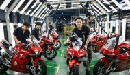 This picture taken on July 20, 2026 shows workers preparing to test assembled motorcycles at the ZXMOTO factory in Chongqing, southwestern China. (Photo by Wang Zhao / AFP) 