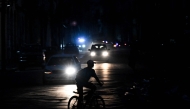 A man rides his bicycle down a street during a blackout in Havana on August 1, 2026. (Photo by Yamil Lage / AFP)