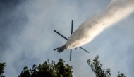 A firefighting helicopter drops water over a wildfire in the area of Porto Germeno, some 70 kilometres (45 miles) northwest of Athens in the region of Viotia, on August 2, 2026. (Photo by Angelos TZORTZINIS / AFP)