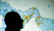 (Files) A photo illustration taken in Nicosia on May 4, 2026, shows a person in front of a large screen displaying vessel movements in the Strait of Hormuz on a ship-tracking website. (Photo by AFP)