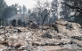 The rubble of a burned out residential home smolders in the Balboa neighborhood of Spokane, Washington, on August 2, 2026. Photo by Erick Doxey / AFP