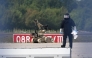 A forensic technician is at work alongside a bomb disposal robot near a Ukrainian cargo plane at Leipzig/Halle Airport in Schkeuditz, eastern Germany on August 5, 2026, after an explosives-laden drone was found near the plane overnight, and another aircraft collided with an unknown flying object mid-air nearby before landing safely. Photo by Hendrik Schmidt / dpa / AFP