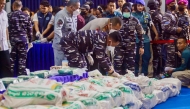 Officers from various Indonesian agencies prepare sacks containing ketamine during a press conference revealing an international narcotics smuggling case in Batam, Riau Islands, on August 9, 2026. Photo by ANDARU AK / AFP